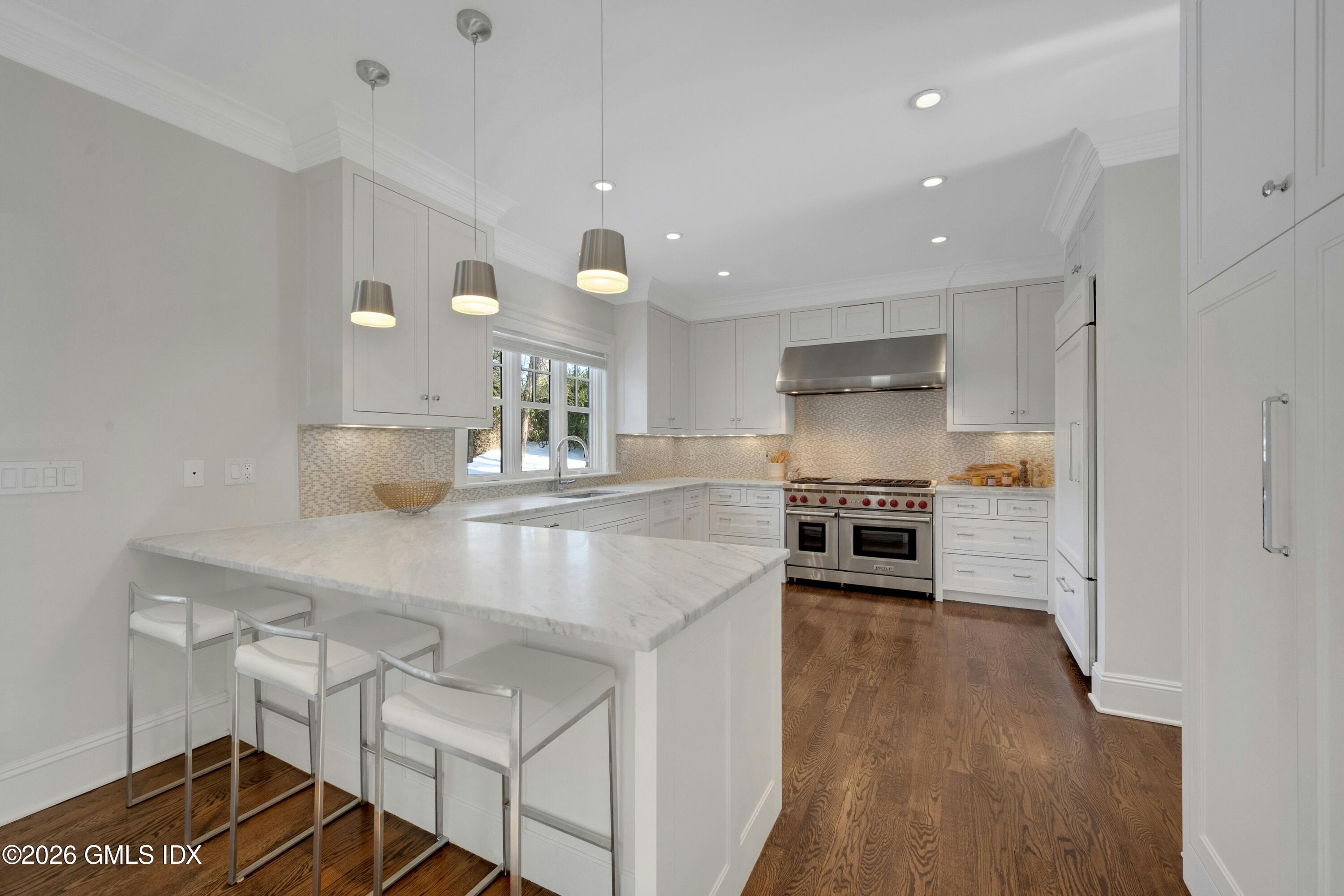17 Pintail Lane Greenwich, CT 06830 - Photo 9 of 31 a kitchen with kitchen island a stove a table and chairs in it