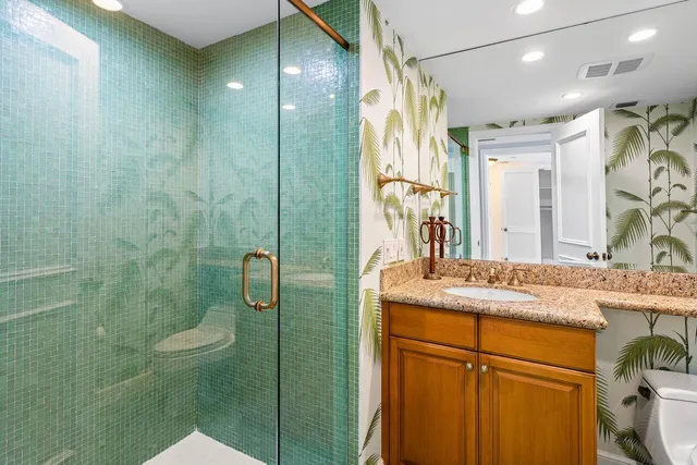 a bathroom with a granite countertop sink toilet and shower