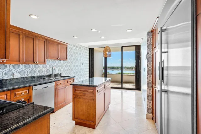 a kitchen with stainless steel appliances granite countertop a refrigerator and a sink