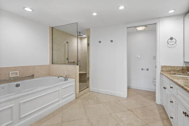 a bathroom with a tub a sink and a mirror