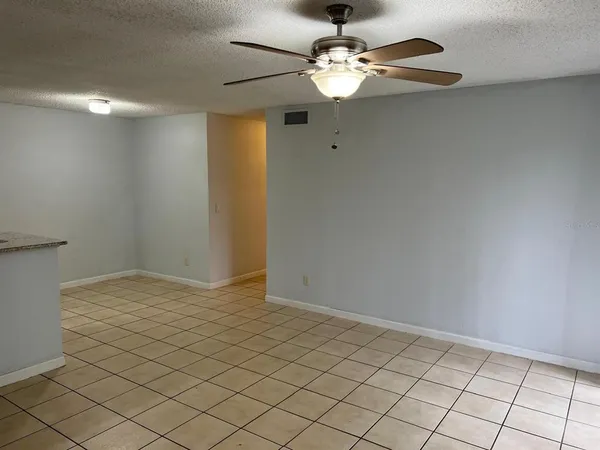 a view of an empty room and a chandelier fan