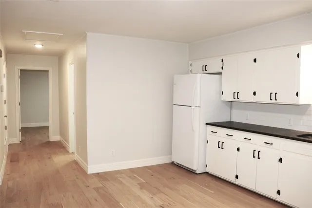 a kitchen with granite countertop white cabinets and white appliances