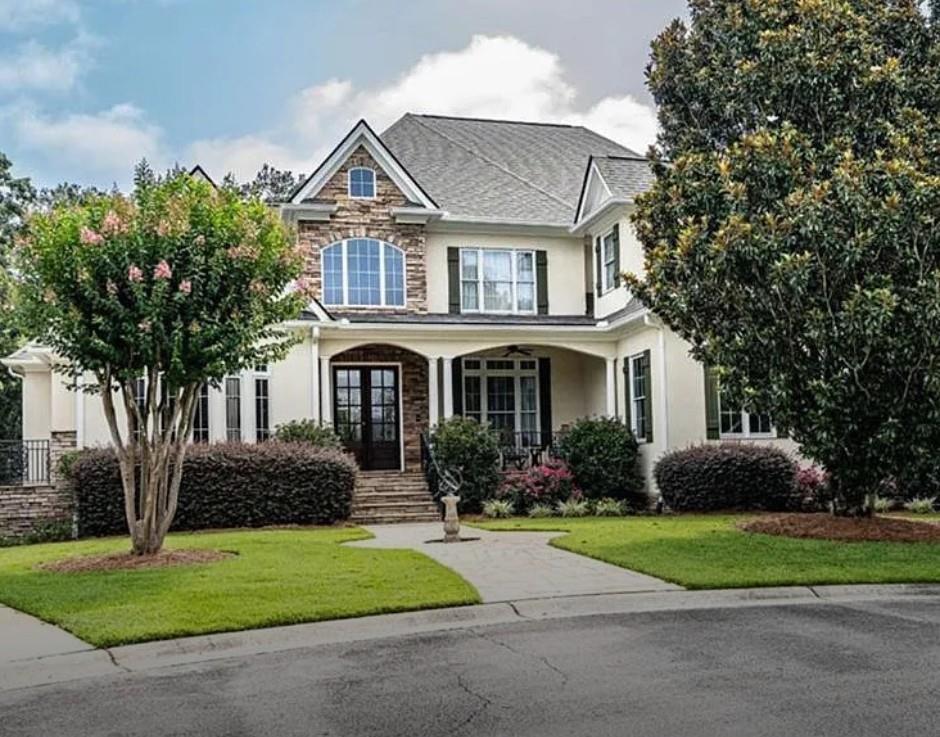 a front view of a house with a yard and trees