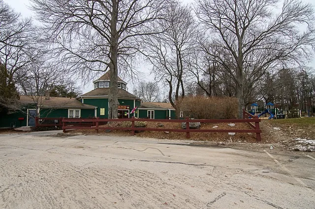 a front view of a house with a yard covered with snow