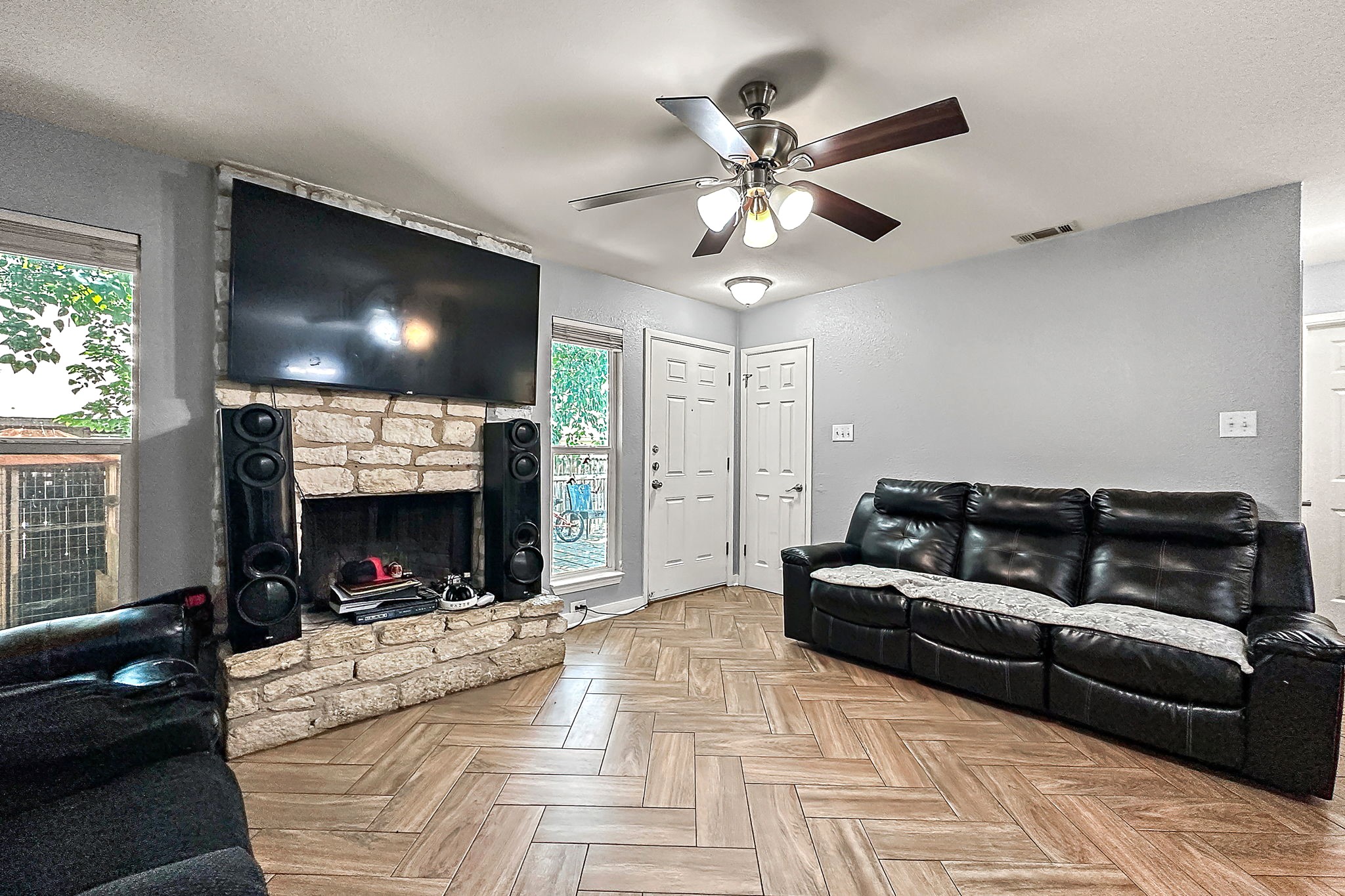 700 Misty Morning Way Round Rock, TX 78664 - Photo 4 of 36 Unit B - A stone fireplace anchors this inviting living space, complemented by beautiful herringbone pattern wood-look tile flooring.