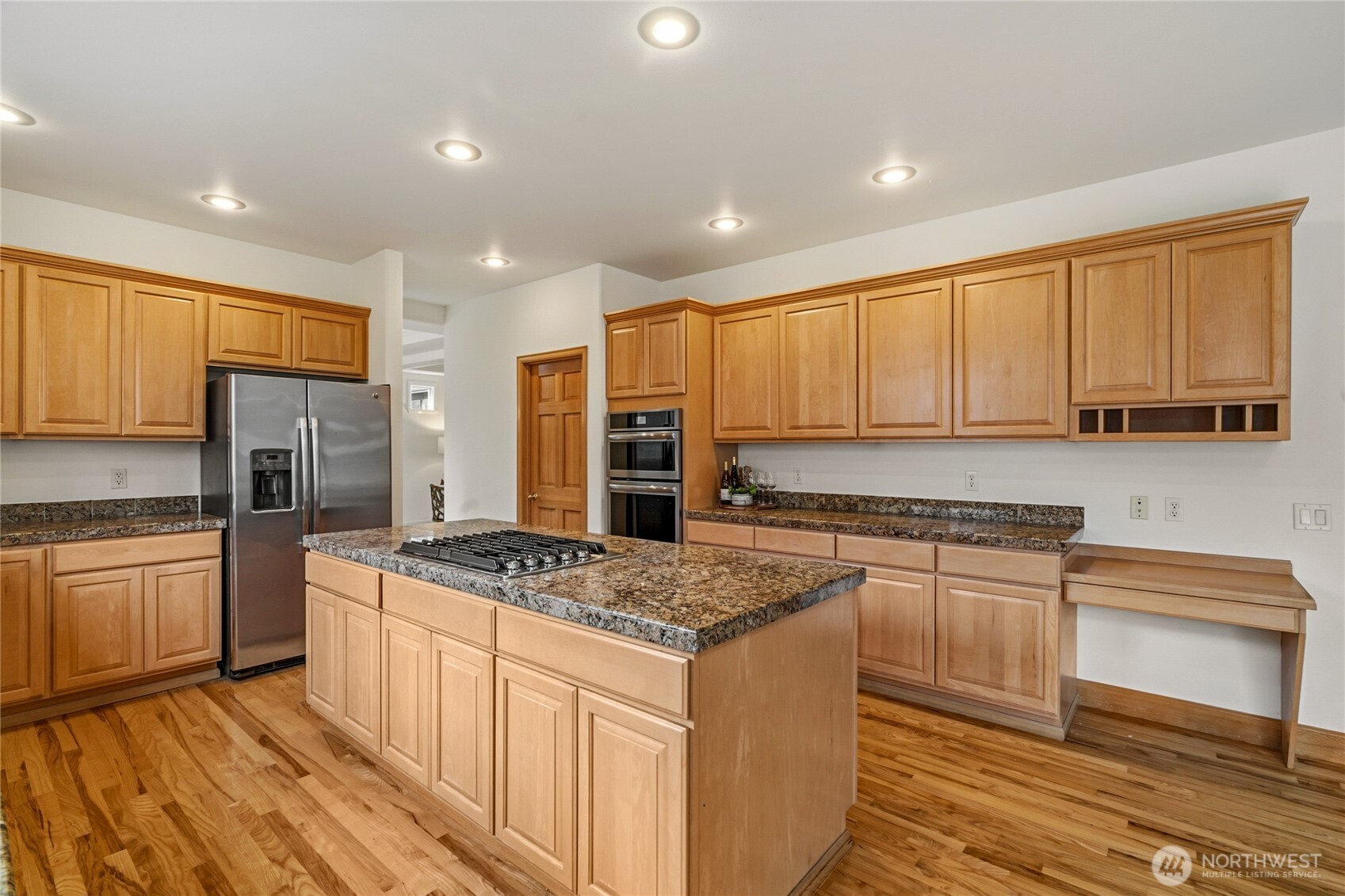 18639 175th Avenue Southeast Renton, WA 98058 - Photo 12 of 37 a kitchen with stainless steel appliances granite countertop a stove a sink dishwasher a refrigerator and white cabinets with wooden floor