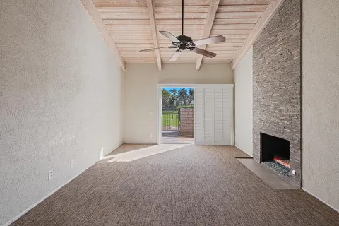 a view of a hallway with wooden floor and a ceiling fan
