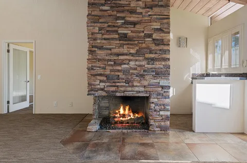 a view of empty room with wooden floor and fireplace