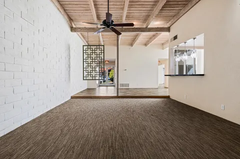 a view of a livingroom with wooden floor and a ceiling fan