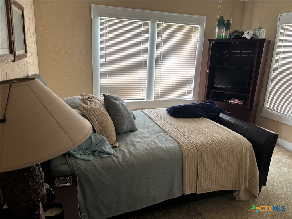 613 East Broadway Street, Unit 5 Cuero, TX 77954 - Photo 13 of 34 a bedroom with a bed and a mirror