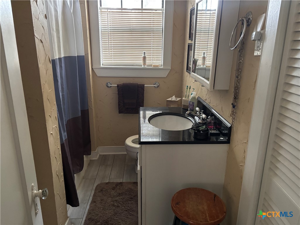 613 East Broadway Street, Unit 5 Cuero, TX 77954 - Photo 14 of 34 a bathroom with a sink a toilet and a mirror