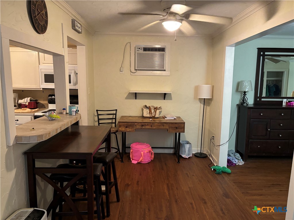 613 East Broadway Street, Unit 5 Cuero, TX 77954 - Photo 18 of 34 a living room with a table chairs and a refrigerator