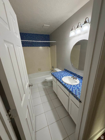 1563 South 600 East Springville, UT 84663 - Photo 19 of 30 Bathroom featuring a white vanity with a blue mosaic tile countertop, an integrated white sink, and a circular wall mirror