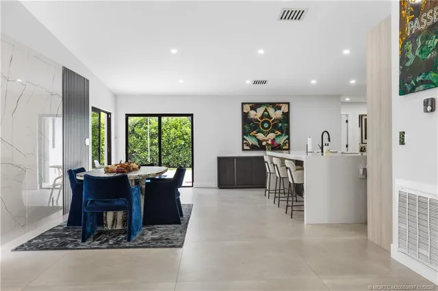 a living room with furniture a large window and a dining table