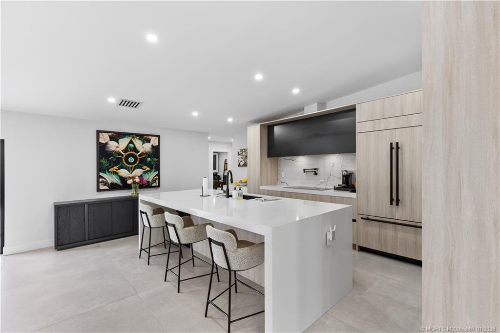 5143 Deerhurst Crescent Circle Boca Raton, FL 33486 - Photo 15 of 47 a kitchen with stainless steel appliances a sink a stove a refrigerator with white cabinets and wooden floor