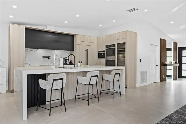 a kitchen with stainless steel appliances kitchen island granite countertop a sink and cabinets