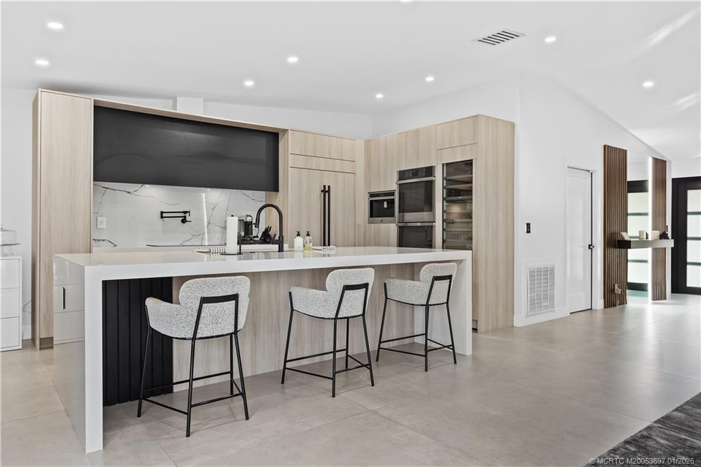 5143 Deerhurst Crescent Circle Boca Raton, FL 33486 - Photo 17 of 47 a kitchen with stainless steel appliances kitchen island granite countertop a sink and cabinets