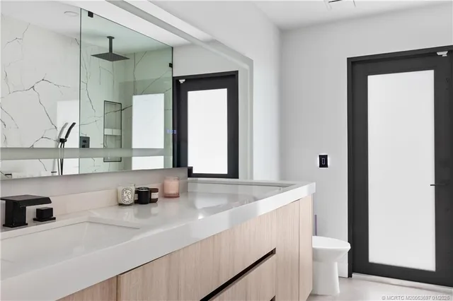 a bathroom with a sink a toilet and a mirror