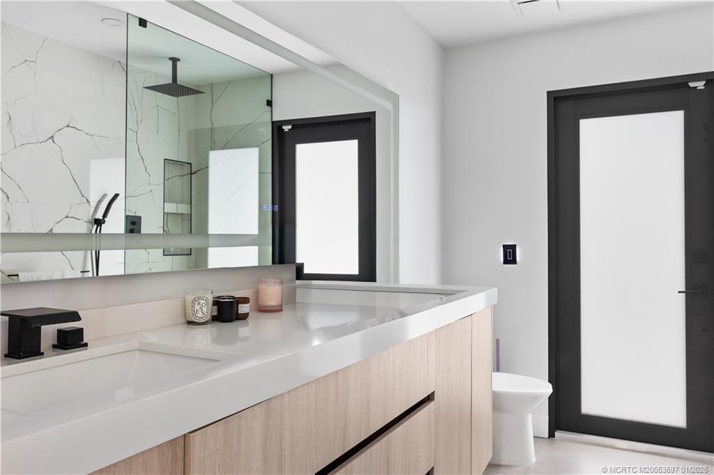 5143 Deerhurst Crescent Circle Boca Raton, FL 33486 - Photo 26 of 47 a bathroom with a sink a toilet and a mirror