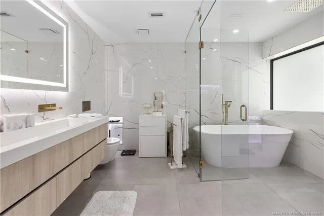 a spacious bathroom with a double vanity sink mirror and a bathtub