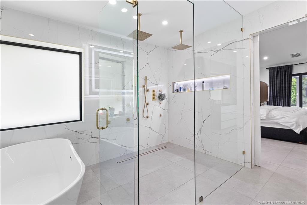 5143 Deerhurst Crescent Circle Boca Raton, FL 33486 - Photo 9 of 47 a bathroom with a bathtub and a shower