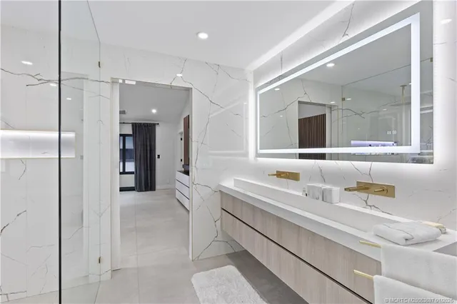 a bathroom with a sink a large mirror and a shower