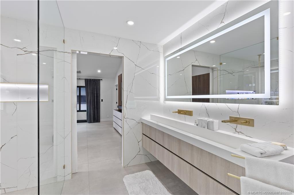 5143 Deerhurst Crescent Circle Boca Raton, FL 33486 - Photo 10 of 47 a bathroom with a sink a large mirror and a shower