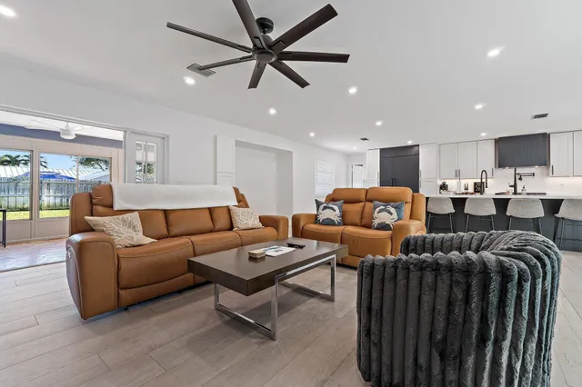 a living room with furniture a ceiling fan and a window