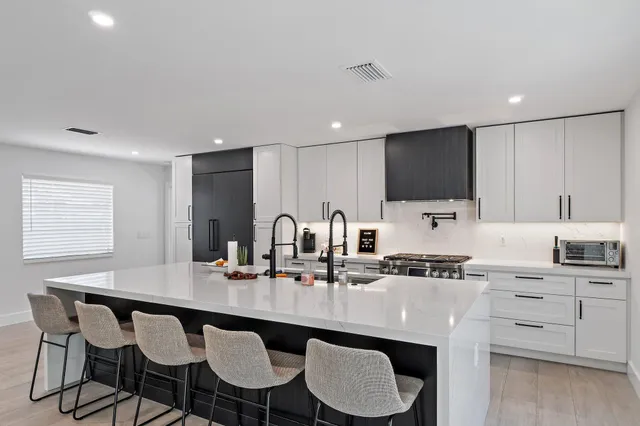 a kitchen with granite countertop a sink and white appliances