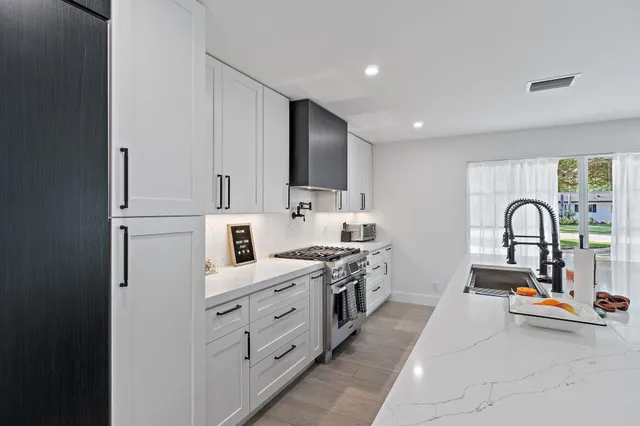 a kitchen with white cabinets and appliances