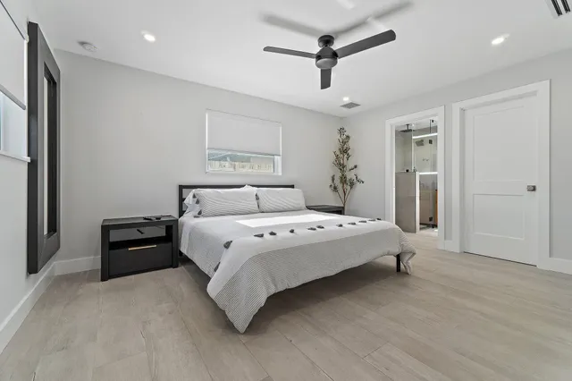 a spacious bedroom with a bed and a chandelier