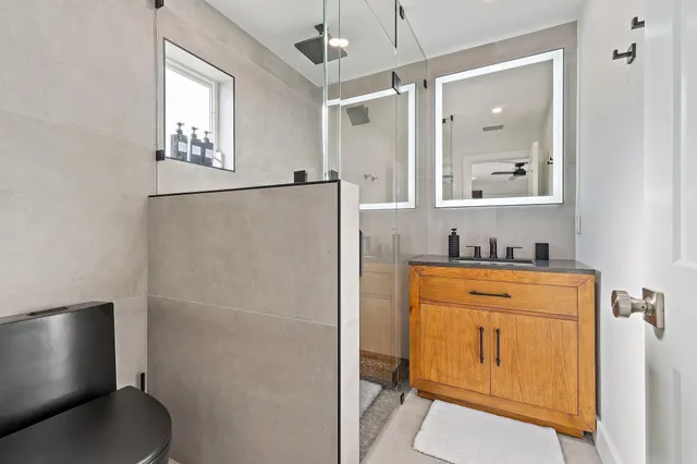 a bathroom with a granite countertop sink toilet and shower
