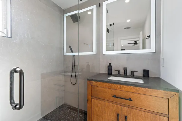 a bathroom with a shower sink and mirror