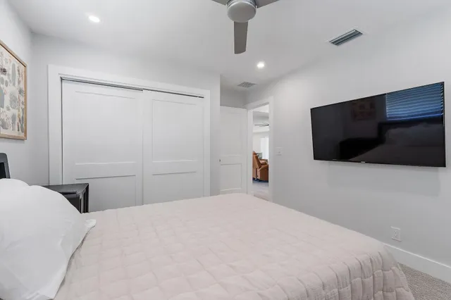 a bedroom with a large bed and a flat screen tv