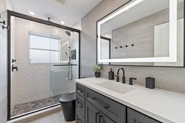 a bathroom with a sink a toilet and shower