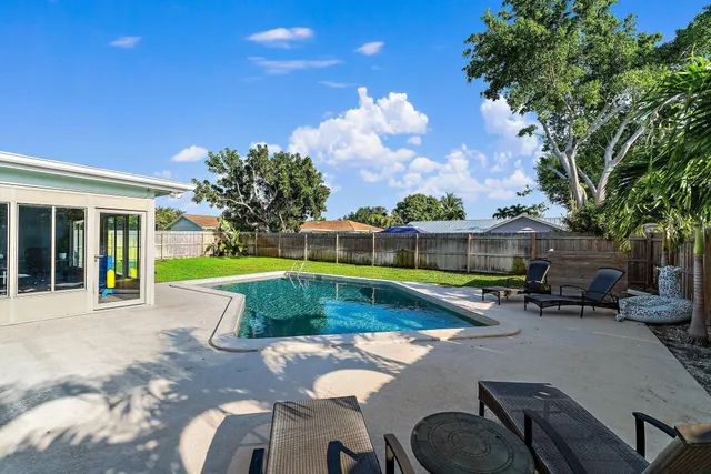 a view of a house with swimming pool and sitting area