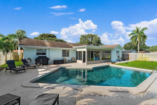 a view of a house with backyard sitting area and swimming pool