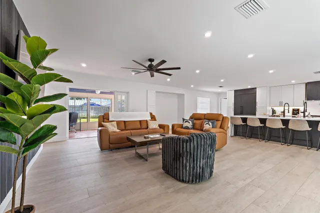 a living room with furniture a window and a potted plant