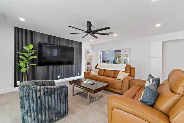 a living room with furniture a flat screen tv and a potted plant