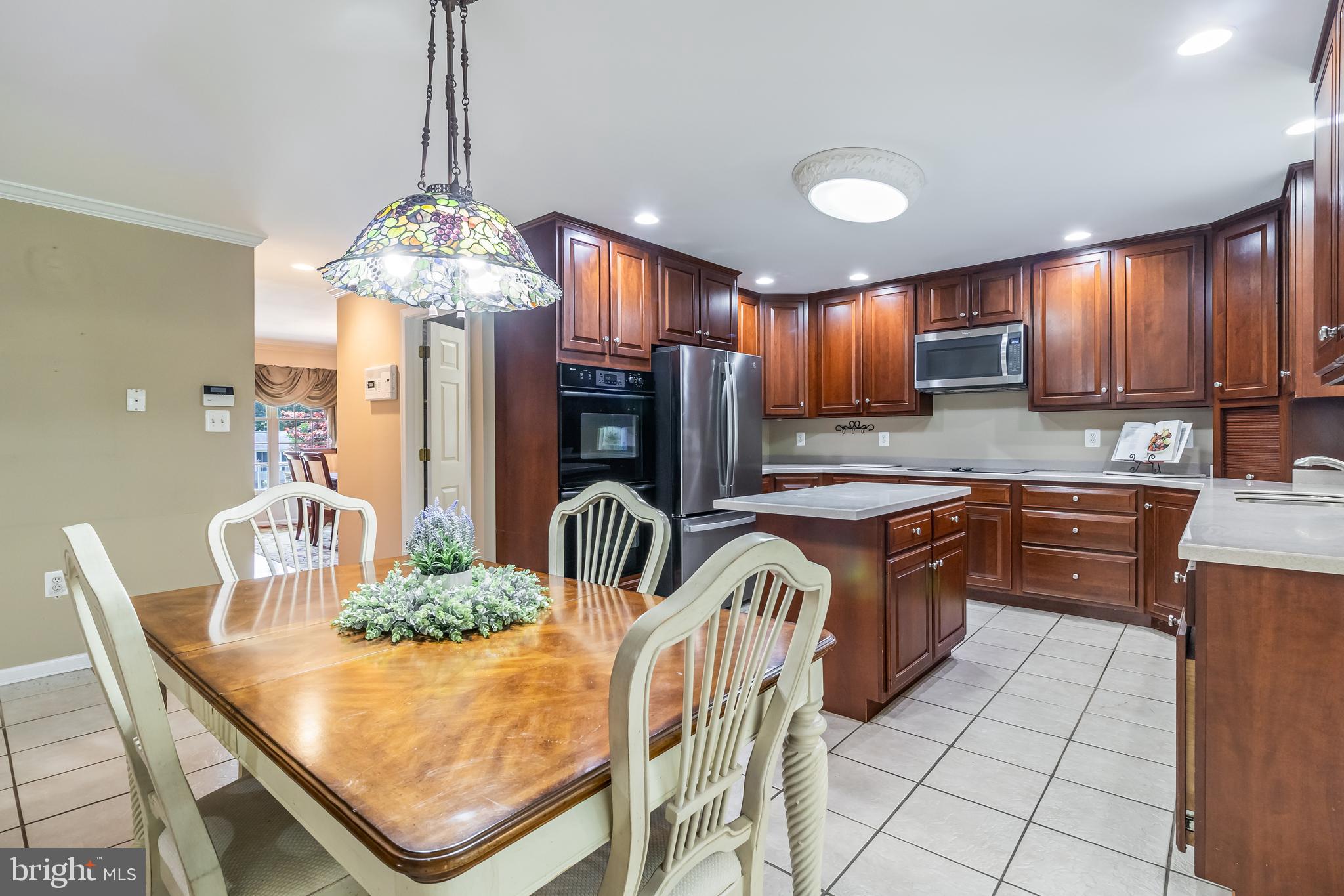 203 Morgans Ridge Court La Plata, MD 20646 - Photo 13 of 59 a kitchen with stainless steel appliances granite countertop a stove a refrigerator a sink dishwasher a dining table and chairs with wooden floor