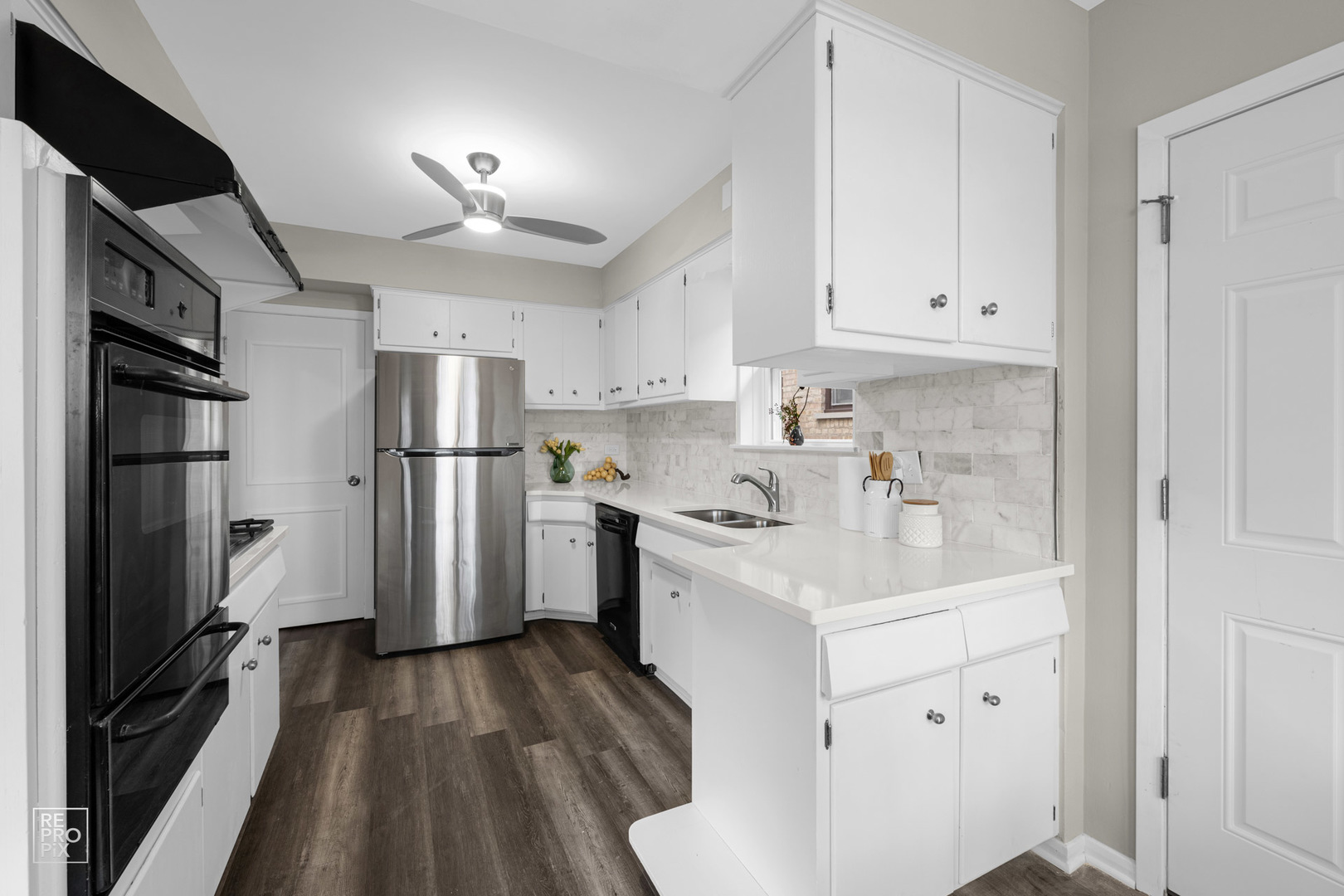 4319 West Devon Avenue Chicago, IL 60646 - Photo 4 of 10 a kitchen with white cabinets and stainless steel appliances