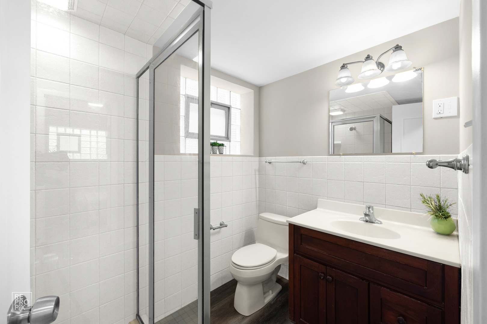 4319 West Devon Avenue Chicago, IL 60646 - Photo 6 of 10 a bathroom with a toilet a sink and mirror