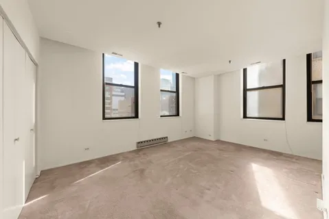 an empty room with windows and closet