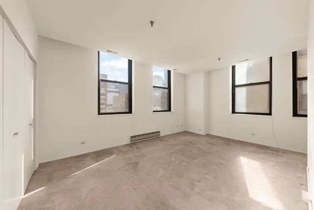 an empty room with windows and closet