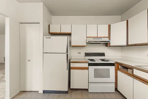 a kitchen with white cabinets and white appliances