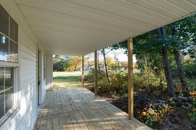 a view of a swimming pool with a yard and large trees