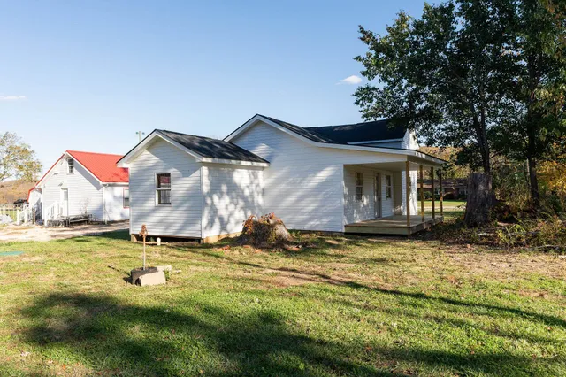 a view of a house with backyard and trees