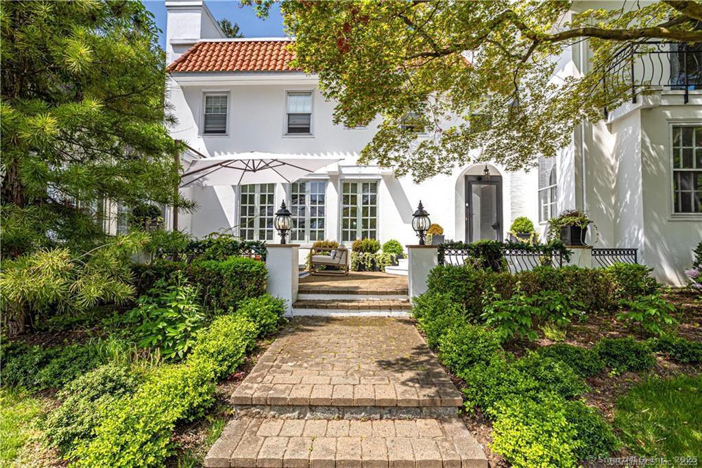 a front view of a house with a garden