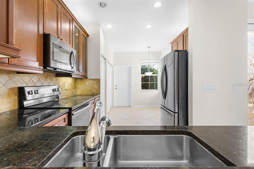 16252 Amethyst Key Drive Wimauma, FL 33598 - Photo 12 of 47 a kitchen with stainless steel appliances granite countertop a refrigerator and a sink
