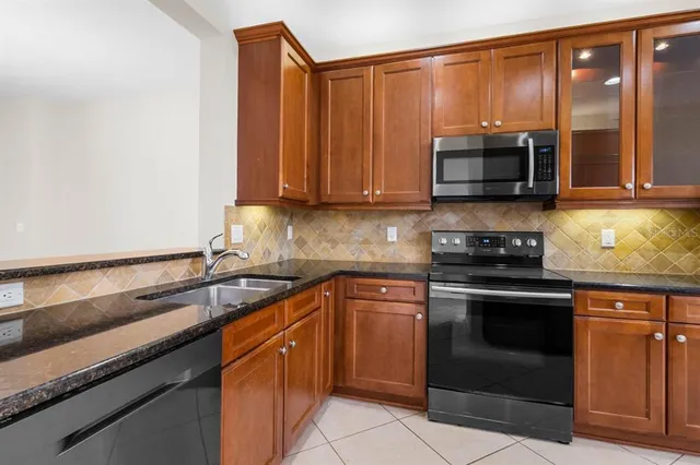 a kitchen with stainless steel appliances granite countertop a sink stove and microwave
